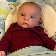 James Bleu is registered to the contest to win money with this photo: baby, infant, child, onesie, blanket, cushion, pattern, clouds, blue, maroon, face, head, person, portrait, indoor, soft, comfort, newborn, lying, curious