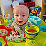 Maximo is registered to the contest to win money with this photo: architecture, baby, bowl, building, cream, cutlery, dessert, face, furniture, happy, head, indoors, livingroom, person, photography, portrait, room, sitting, spoon, toy