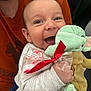 baby, child, smiling, plush_toy, yoda, candy_cane, red_ribbon, person, adult, orange_shirt, happy, holding, closeup, indoor, cute, face, hand, clothing, holiday, joyful