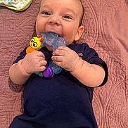 Logan James joined the competition — help win amazing prizes! baby, infant, teething_toy, smiling, diaper, pampers, blue_shirt, blanket, play, cute, hand, face, child, lying_down, happy, indoors, toy, colorful, young_child, bib