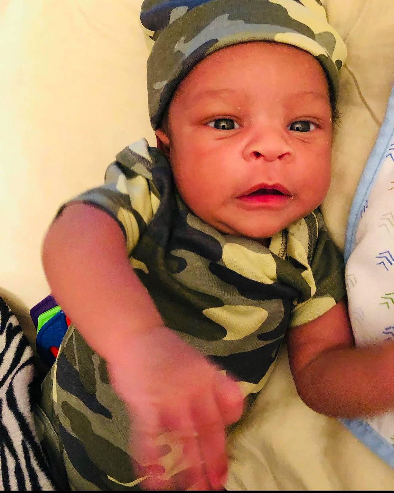 Dujhayne is registered to the contest to win money with this photo: arm, baby, cap, cheek, chin, comfort, ear, eyebrow, eyelash, finger, forehead, gesture, happy, headwear, iris, lip, mouth, neck, nose, person