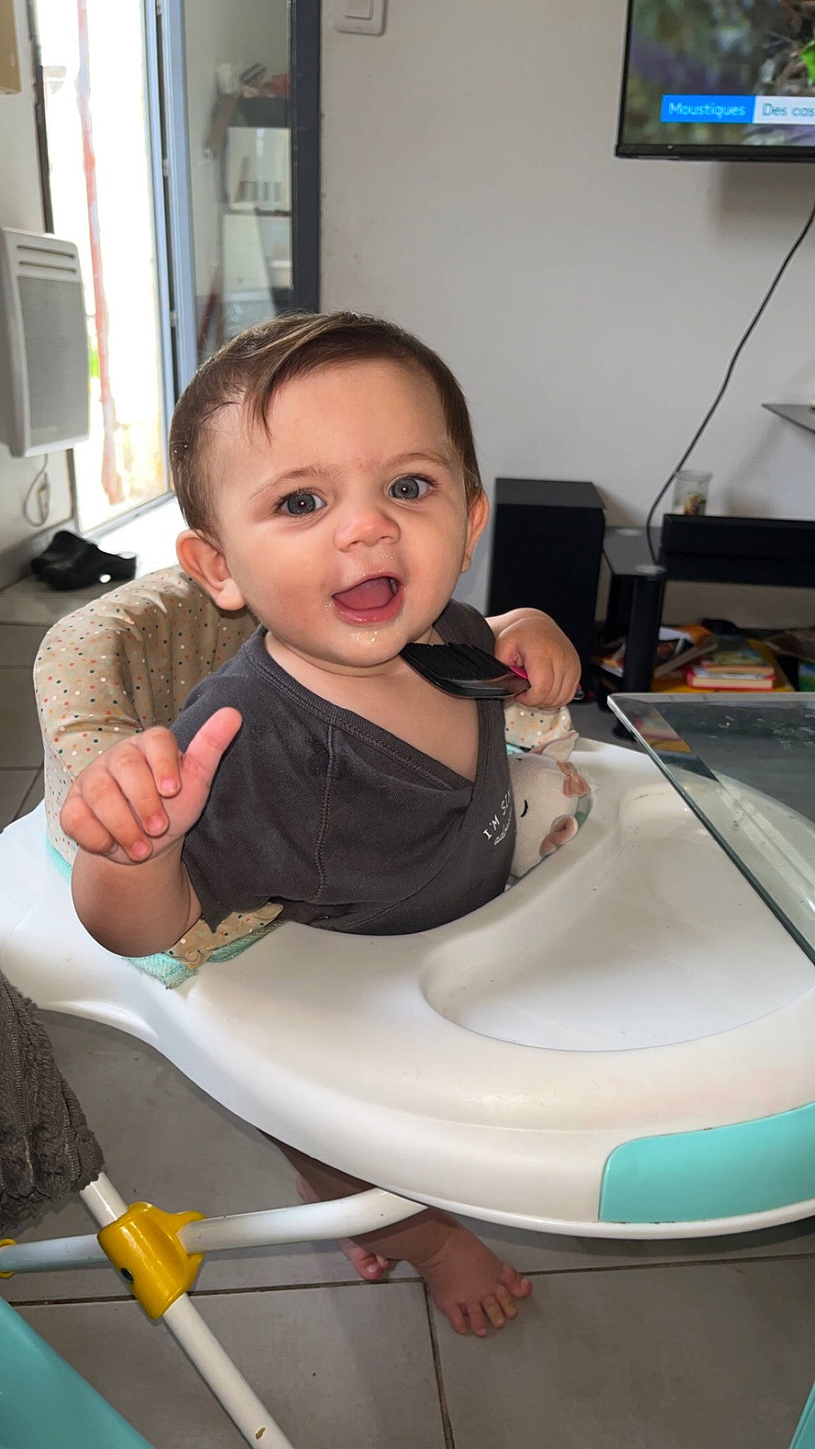 Nina a rejoint le concours — aidez-le/la à gagner de superbes lots ! baby, baby_toddler_clothing, chair, cheek, child, comfort, facial_expression, flooring, fun, hairstyle, happy, head, home_appliance, person, sitting, skin, smile, standing, television, thumb