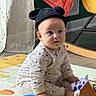 baby, child, infant, portrait, sitting, indoors, playroom, toys, toy_mat, bear_hat, knit_hat, onesie, patterned_clothing, wide_eyes, looking_at_camera, face, hands, feet, colorful, home