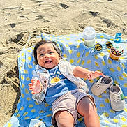 Shlok joined the competition — help win amazing prizes! baby, smiling, beach, sand, blanket, hat, baby_shoes, bottle, sunglasses, cupcake, birthday_candle, sunlight, happy, child, clothing, outdoor, celebration, footwear, infant, playful