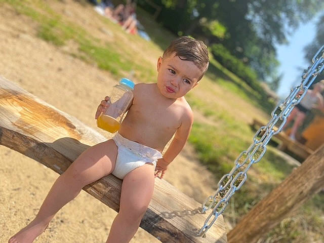 Maylon participe au concours pour gagner de l'argent avec cette photo : barefoot, blond, chest, child, fun, grass, happy, human_leg, leisure, outdoor_play_equipment, people_in_nature, person, plant, recreation, shorts, sitting, swing, thigh, toddler, trunk