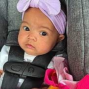 Khylan joined the competition — help win amazing prizes! baby, infant, headband, bow, car_seat, blanket, fleece, colorful, pink, orange, green, clothing, face, hand, person, seatbelt, cute, portrait, indoor, child