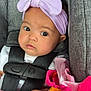 baby, infant, headband, bow, car_seat, blanket, fleece, colorful, pink, orange, green, clothing, face, hand, person, seatbelt, cute, portrait, indoor, child