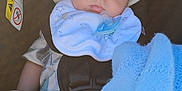 Ayden is registered to the contest to win money with this photo: baby, infant, car_seat, hat, bib, pacifier, blanket, blue, clothing, socks, face, child, young, seatbelt, safety, resting, indoors, closeup, cute, newborn