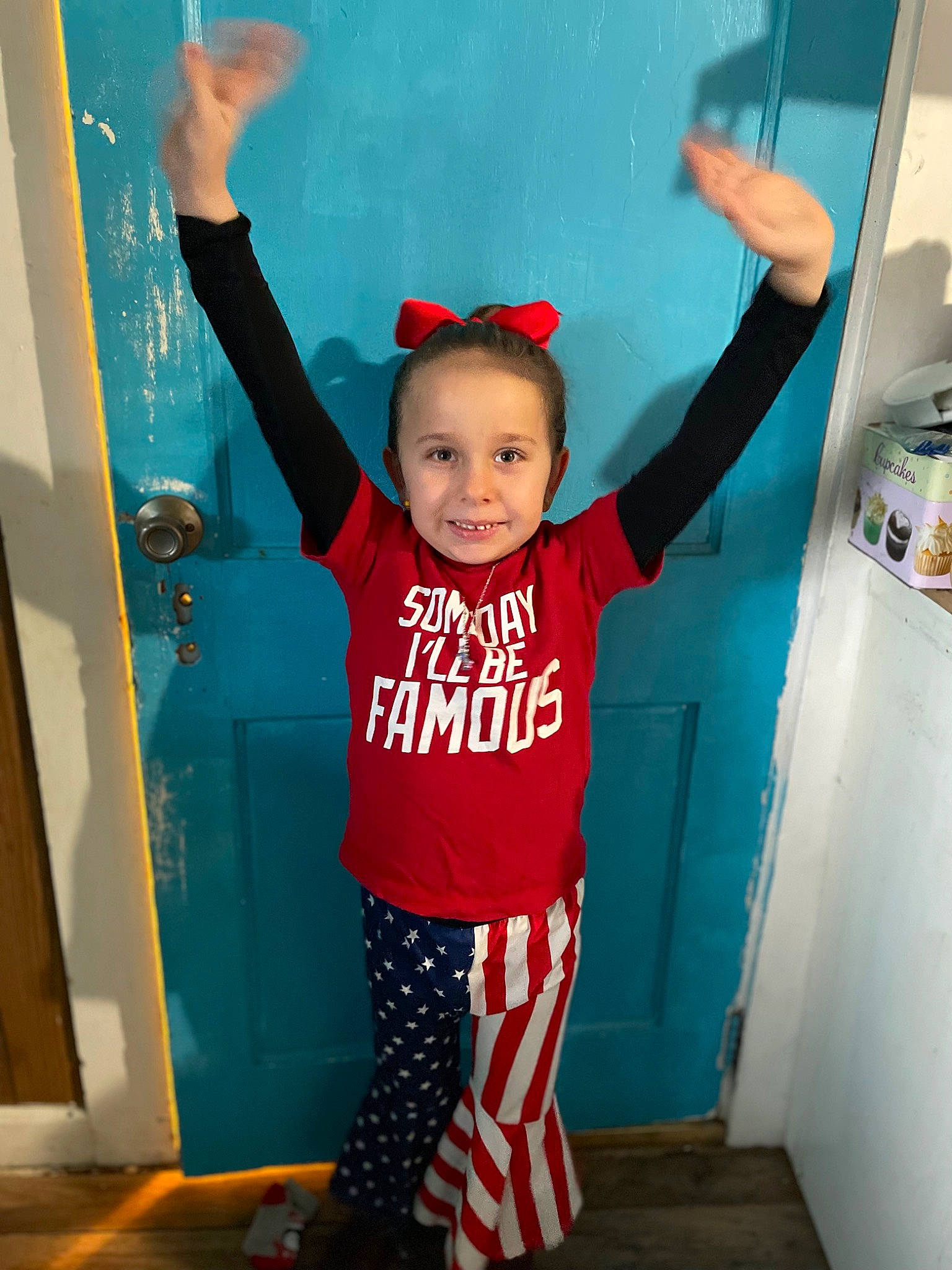 Madelynn is registered to the contest to win money with this photo: baby_toddler_clothing, child, design, door, electric_blue, fun, gesture, happy, joint, joy, orange, people, person, product, red, sleeve, smile, sportswear, standing, sweatpant