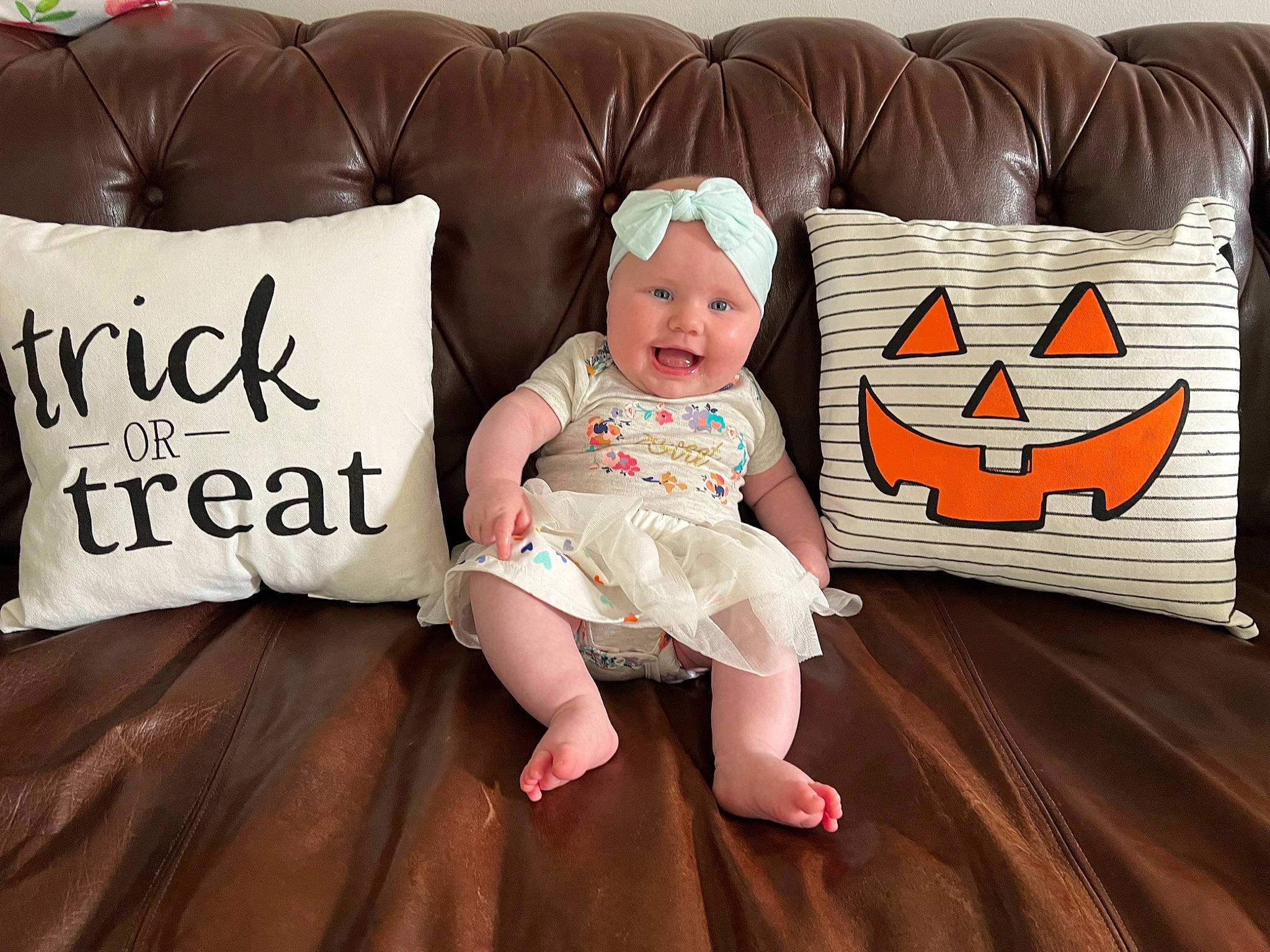 Georgia is registered to the contest to win money with this photo: baby, baby_toddler_clothing, child, comfort, couch, flooring, font, happy, headwear, linens, living_room, mammal, person, pillow, product, room, sleeve, studio_couch, textile, throw_pillow