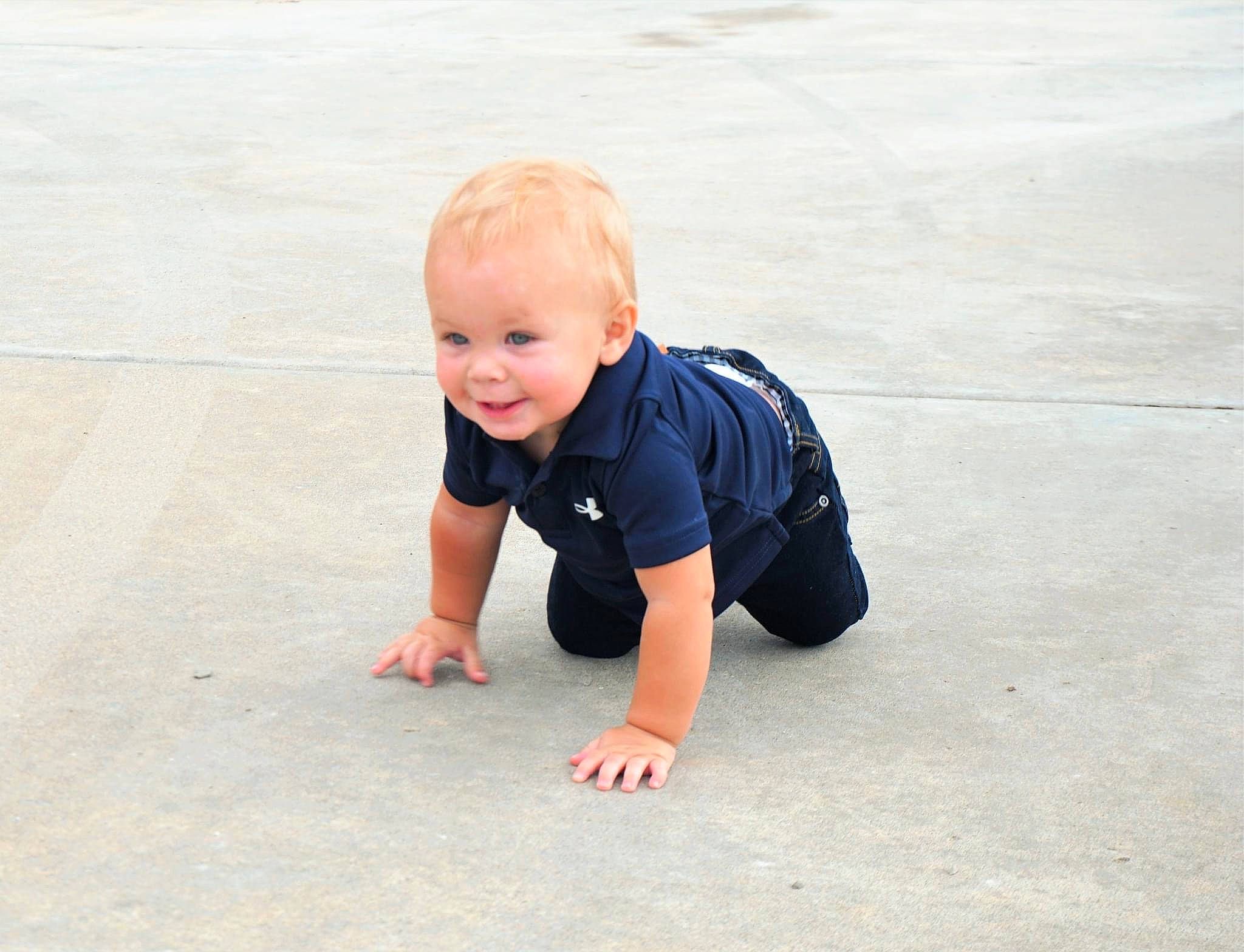 Kai is registered to the contest to win money with this photo: asphalt, baby, baby_toddler_clothing, child, crawling, dress, floor, flooring, fun, grass, happy, pattern, person, plant, recreation, road_surface, smile, t_shirt, toddler, tree