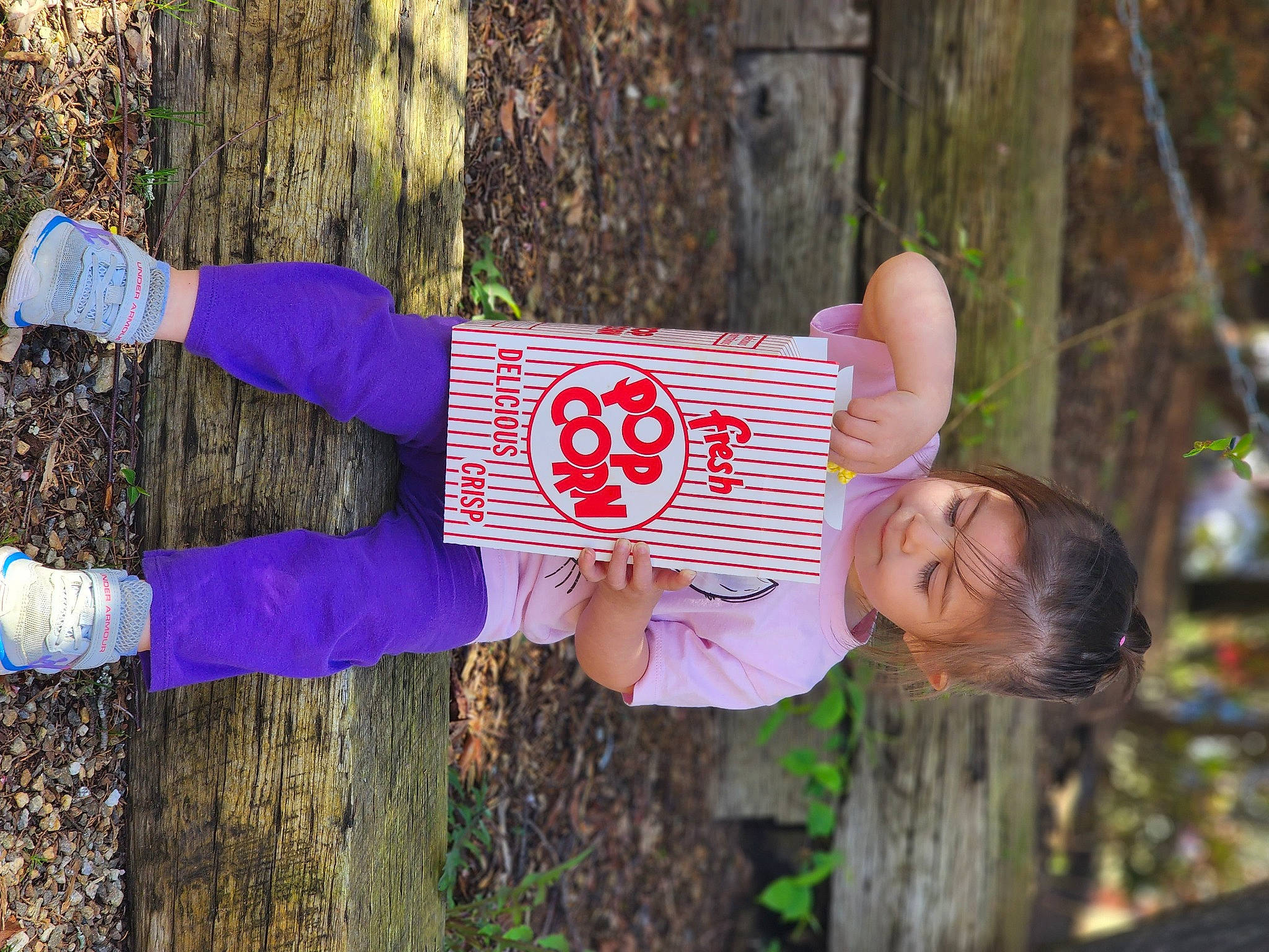Adelyn is registered to the contest to win money with this photo: electric_blue, forest, fun, glove, grass, happy, leisure, magenta, people_in_nature, person, plant, portrait_photography, recreation, soil, tree, trunk, wood