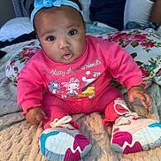 Asani joined the competition — help win amazing prizes! baby, infant, girl, headband, bow, pink_outfit, sneakers, bed, blanket, pillow, floral_pillow, big_eyes, portrait, sitting, cute, indoor, hand, tongue_out, footwear, adult_arm