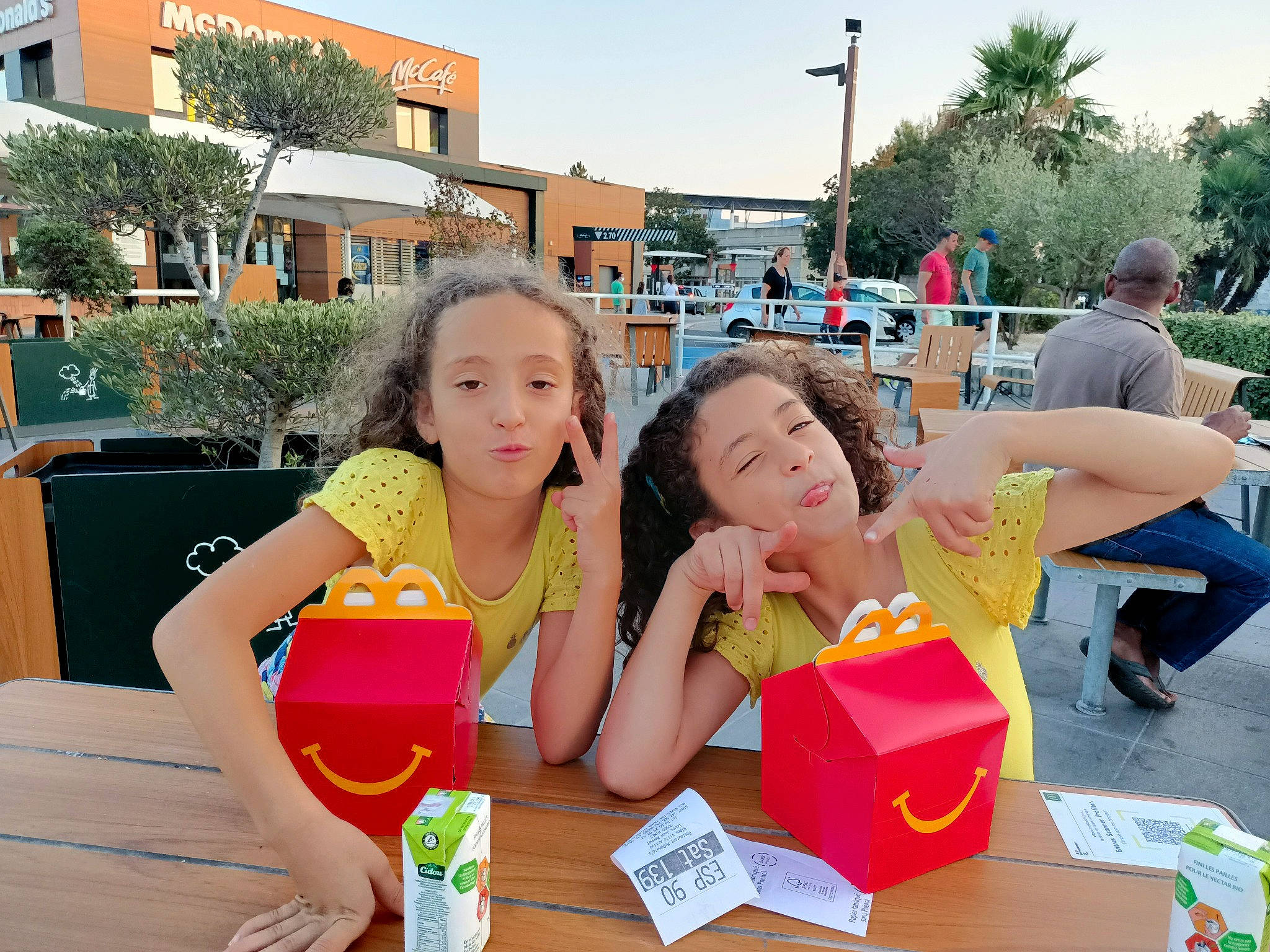 Jade Lina participe au concours pour gagner de l'argent avec cette photo : chair, community, fun, hand, happy, leisure, outdoor_furniture, people, person, photograph, plant, public_space, recreation, sharing, shorts, sky, summer, table, tableware, toddler