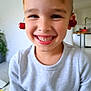 child, boy, smile, cherries, fruit, playful, indoor, happy, face, expression, light, casual_clothing, short_hair, portrait, cute, funny, home, background, joy, cheerful