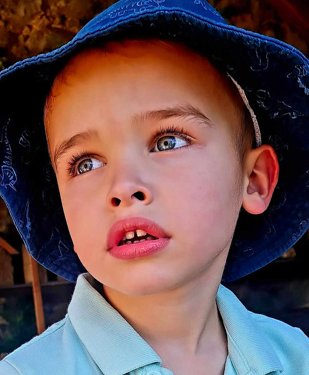 Mathéo a rejoint le concours — aidez-le/la à gagner de superbes lots ! child, boy, face, portrait, hat, blue_hat, eyes, expression, closeup, skin, lip, ear, clothing, polo_shirt, outdoor, daylight, thoughtful, young, casual, headwear