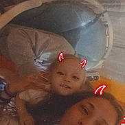 Joshua is registered to the contest to win money with this photo: child, adult, selfie, red_horns, smile, playful, indoors, baby_carrier, curtain, light, face, person, fun, happy, casual, portrait, family, cozy, filter, doodle