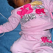 Isayana is registered to the contest to win money with this photo: baby, child, infant, pink_clothing, sweatshirt, sweatpants, blue_towel, pacifier, wide_eyes, expression, lying_down, cute, casual_wear, indoor, person, face, foot, hand, curly_hair, drama
