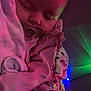 baby, infant, pacifier, sleeping, blanket, swaddle, onesie, floral_pattern, ruffle, nightlight, colored_lights, purple_lighting, cozy, portrait, close_up, face, head, sleepwear, bedding, arm