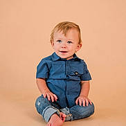 Emmett joined the competition — help win amazing prizes! toddler, child, blue_shirt, jeans, barefoot, sitting, smiling, curly_hair, light_background, studio_photo, cute, portrait, casual_clothing, young_child, happy, innocent, baby, person, indoor, fashion