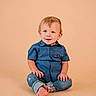 toddler, child, blue_shirt, jeans, barefoot, sitting, smiling, curly_hair, light_background, studio_photo, cute, portrait, casual_clothing, young_child, happy, innocent, baby, person, indoor, fashion
