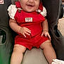 Jaylen is registered to the contest to win money with this photo: baby, smiling, child, red_overalls, white_bow, sneakers, car_seat, cute, happy, infant, indoor, portrait, clothing, footwear, headwear, person, sitting, young_child, cheerful, expression