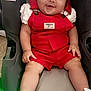 Jaylen joined the competition — help win amazing prizes! baby, child, red_overalls, white_bow, sneakers, car_seat, smiling, indoor, cute, chubby_cheeks, infant, clothing, footwear, person, seat, happy, portrait, headwear, sitting, young