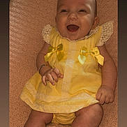 Aria-Louise is registered to the contest to win money with this photo: baby, child, smiling, yellow_dress, lace, bows, blanket, happy, infant, cute, portrait, people, skin, hand, legs, sitting, indoors, closeup, person, baby_clothes