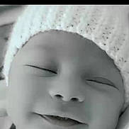 Lucas is registered to the contest to win money with this photo: baby, infant, sleeping, hat, knitted_hat, close_up, face, smile, peaceful, black_and_white, newborn, soft_texture, cute, portrait, child, cozy, blanket, rest, young, headwear