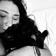 Cash joined the competition — help win amazing prizes! affection, bed, black_and_white, black_cat, blanket, cat, closeup, cuddling, face, hugging, indoor, long_hair, nose_ring, pet, pillow, portrait, sleepy, smartwatch, woman, wrist