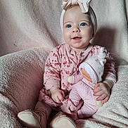 éloïse a rejoint le concours — aidez-le/la à gagner de superbes lots ! baby, child, pink, doll, headband, blue_eyes, pajamas, blanket, soft_toys, cute, smiling, sitting, indoor, portrait, infant, cozy, footwear, hand, face, childhood