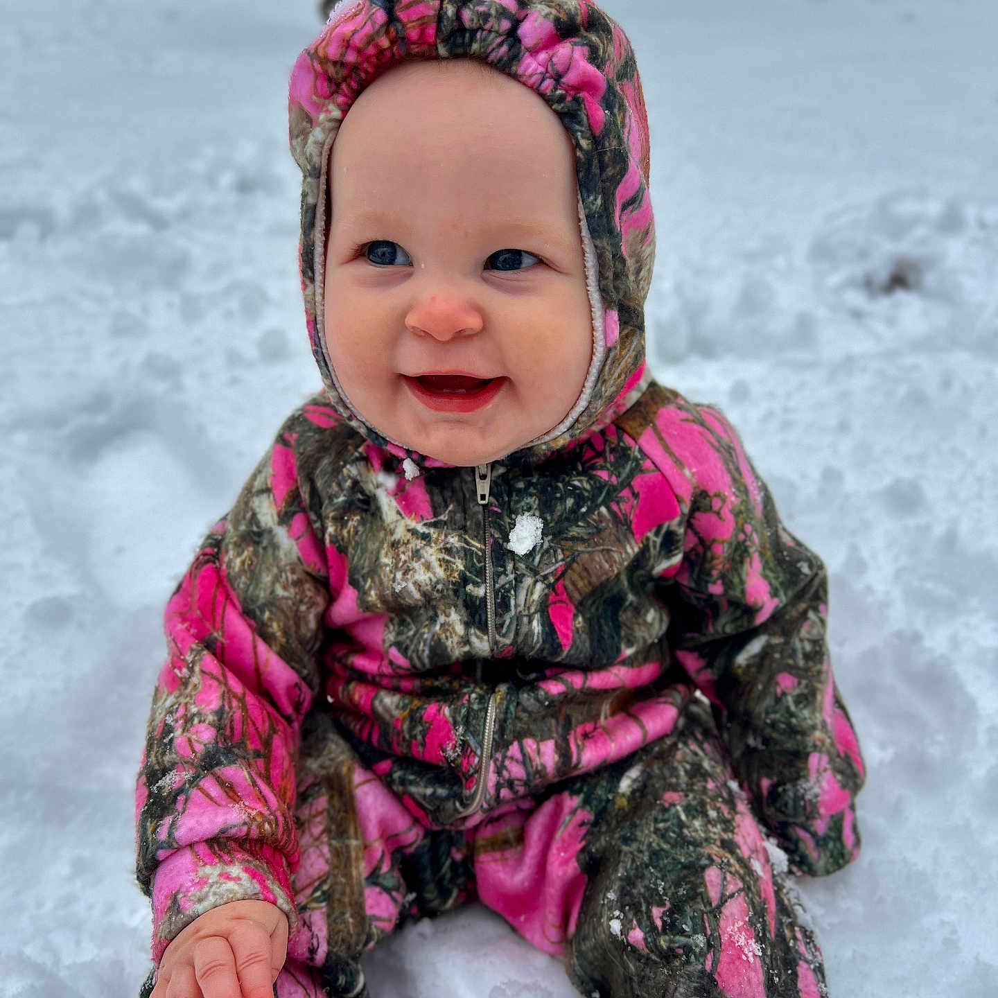 Josie is registered to the contest to win money with this photo: baby, bodypart, bonnet, cap, clothing, coat, face, finger, hand, happy, hat, head, hood, jacket, nature, outdoors, person, photography, portrait, smile