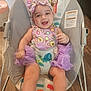baby, infant, smiling, child, bouncer, purple_clothing, headband, tutu, indoor, wooden_floor, cute, happy, person, face, seat, playful, animal_print, toddler, sitting, joyful