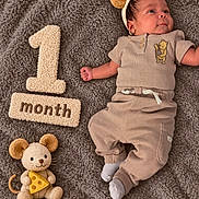 Adriel is registered to the contest to win money with this photo: baby, newborn, infant, one_month_old, portrait, lying_down, smiling, headband, bear_ears, blanket, plush_toy, mouse_toy, cheese, milestone, month_sign, clothing, socks, indoor, cozy, photography
