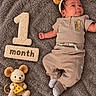 baby, newborn, infant, one_month_old, portrait, lying_down, smiling, headband, bear_ears, blanket, plush_toy, mouse_toy, cheese, milestone, month_sign, clothing, socks, indoor, cozy, photography