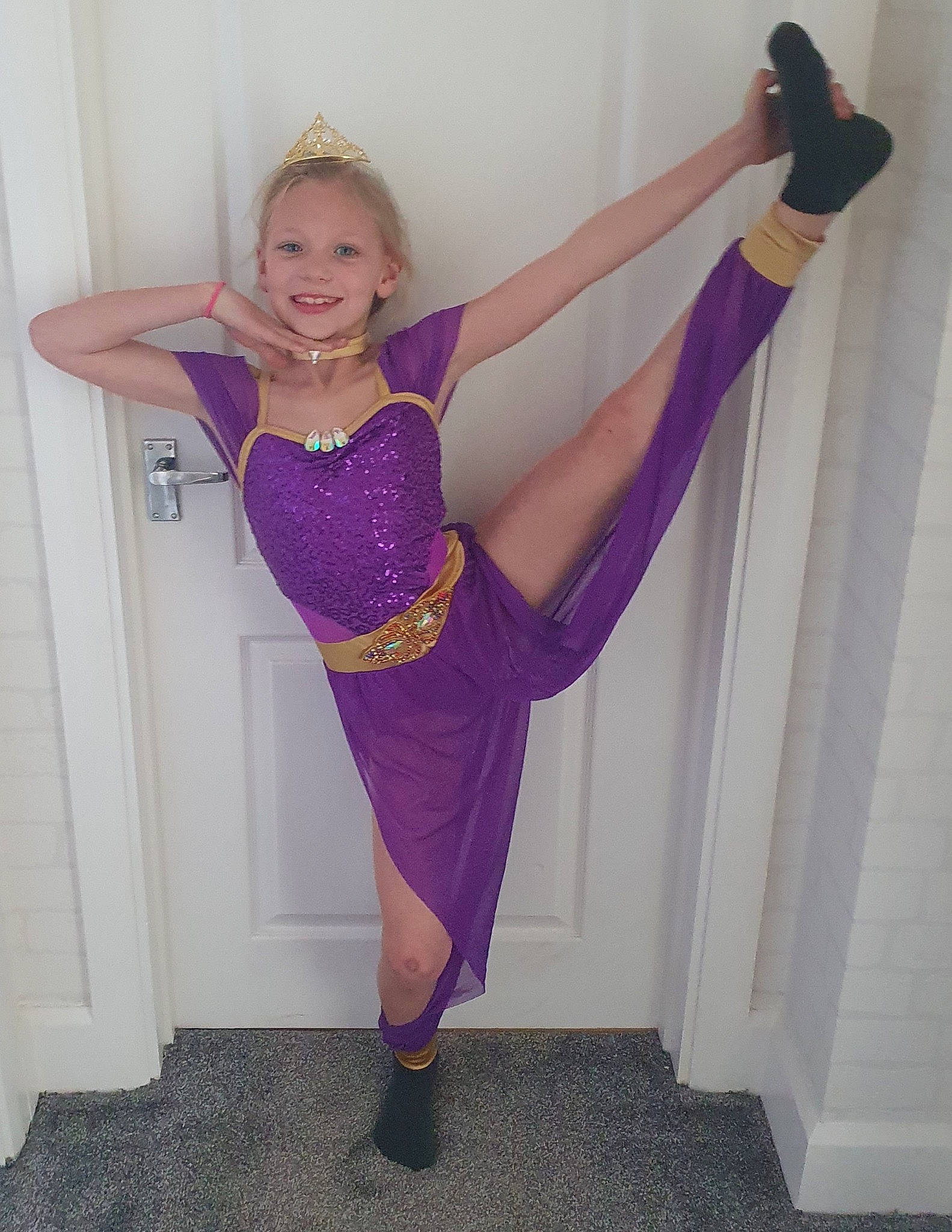 Eryn is registered to the contest to win money with this photo: arm, blond, clothing, costume, dance, footwear, joint, joy, leg, leggings, leotard, muscle, person, pink, purple, shoe, spandex, sportswear, thigh, trousers