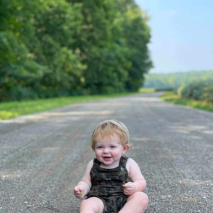 Axel joined the competition — help win amazing prizes! baby, city, clothing, dress, face, grass, head, pants, path, person, photography, plant, portrait, road, sitting, street, tree, urban, vegetation, walking