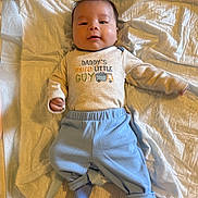 Treyvon joined the competition — help win amazing prizes! baby, infant, child, lying_down, blanket, clothing, blue_pants, socks, face, hair, expression, indoor, soft_texture, cute, person, newborn, smile, cozy, fabric, resting