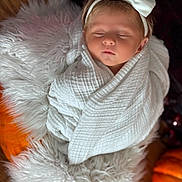 Evie is registered to the contest to win money with this photo: baby, sleeping, white_bow, headband, blanket, wrapped, fluffy_rug, pumpkin, autumn, cozy, soft_texture, infant, child, peaceful, indoors, portrait, cute, newborn, resting, warm