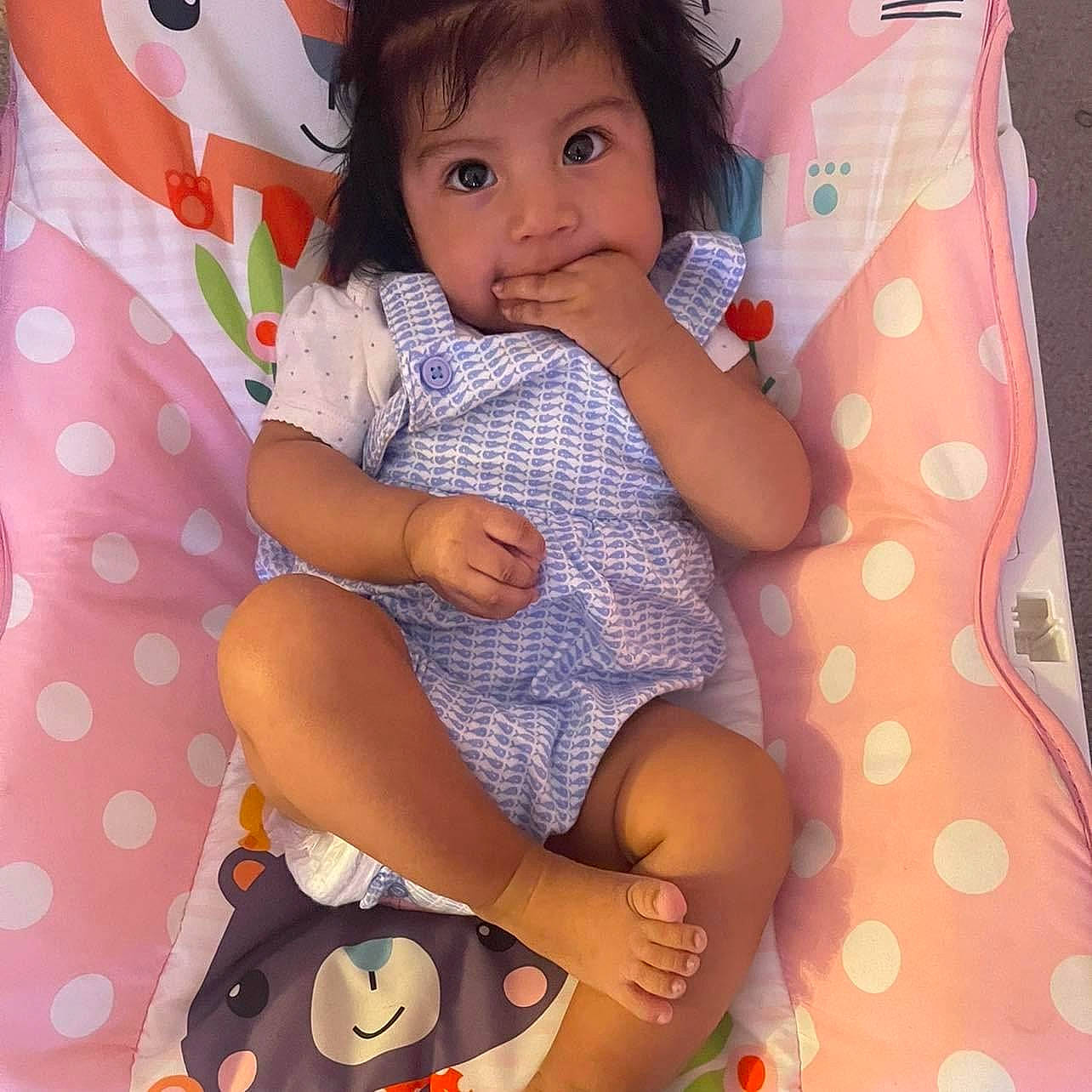 Saraí is registered to the contest to win money with this photo: arm, baby_toddler_clothing, cheek, comfort, finger, hand, happy, head, human_body, knee, lap, neck, pattern, person, pink, shorts, skin, sleeve, textile, thigh