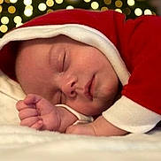 Dean is registered to the contest to win money with this photo: baby, sleeping, infant, red_clothing, white_trim, bokeh, lights, closeup, peaceful, cozy, face, hand, soft, cute, holiday, festive, portrait, newborn, resting, warm