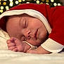baby, sleeping, infant, red_clothing, white_trim, bokeh, lights, closeup, peaceful, cozy, face, hand, soft, cute, holiday, festive, portrait, newborn, resting, warm