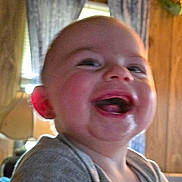 Dean joined the competition — help win amazing prizes! baby, child, laughing, indoor, face, closeup, curtains, wood_paneling, smile, cheeks, person, infant, happy, expression, clothing, head, mouth, tongue, skin, hand