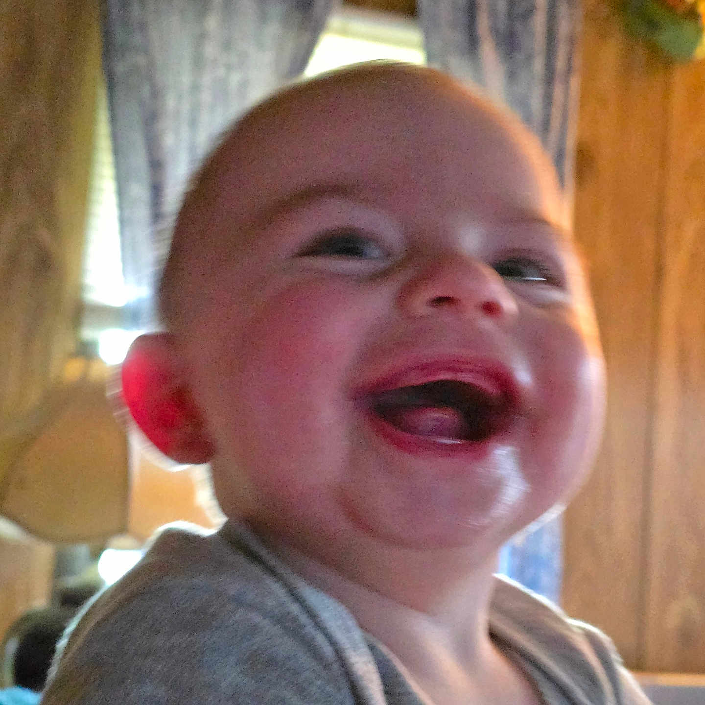 Dean joined the competition — help win amazing prizes! baby, child, laughing, indoor, face, closeup, curtains, wood_paneling, smile, cheeks, person, infant, happy, expression, clothing, head, mouth, tongue, skin, hand