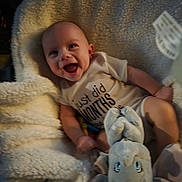 Dean is registered to the contest to win money with this photo: baby, blanket, child, comfortable, cozy, cute, elephant_toy, expression, fabric, face, happy, indoors, infant, lying_down, onesie, plush_toy, small_child, smiling, soft_toy, young_child