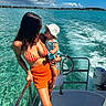 baby, bikini, boat, child, clouds, holding, nature, ocean, outdoor, person, portrait, shorts, sky, summer, sunhat, sunshine, travel, vacation, water, woman