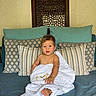 Maë a rejoint le concours — aidez-le/la à gagner de superbes lots ! baby, blue_couch, child, comfortable, couch, cozy, curious, cute, decorative_panel, home, indoor, infant, patterned_pillows, pillows, portrait, sitting, smiling, towel, wooden_panel, wrapped