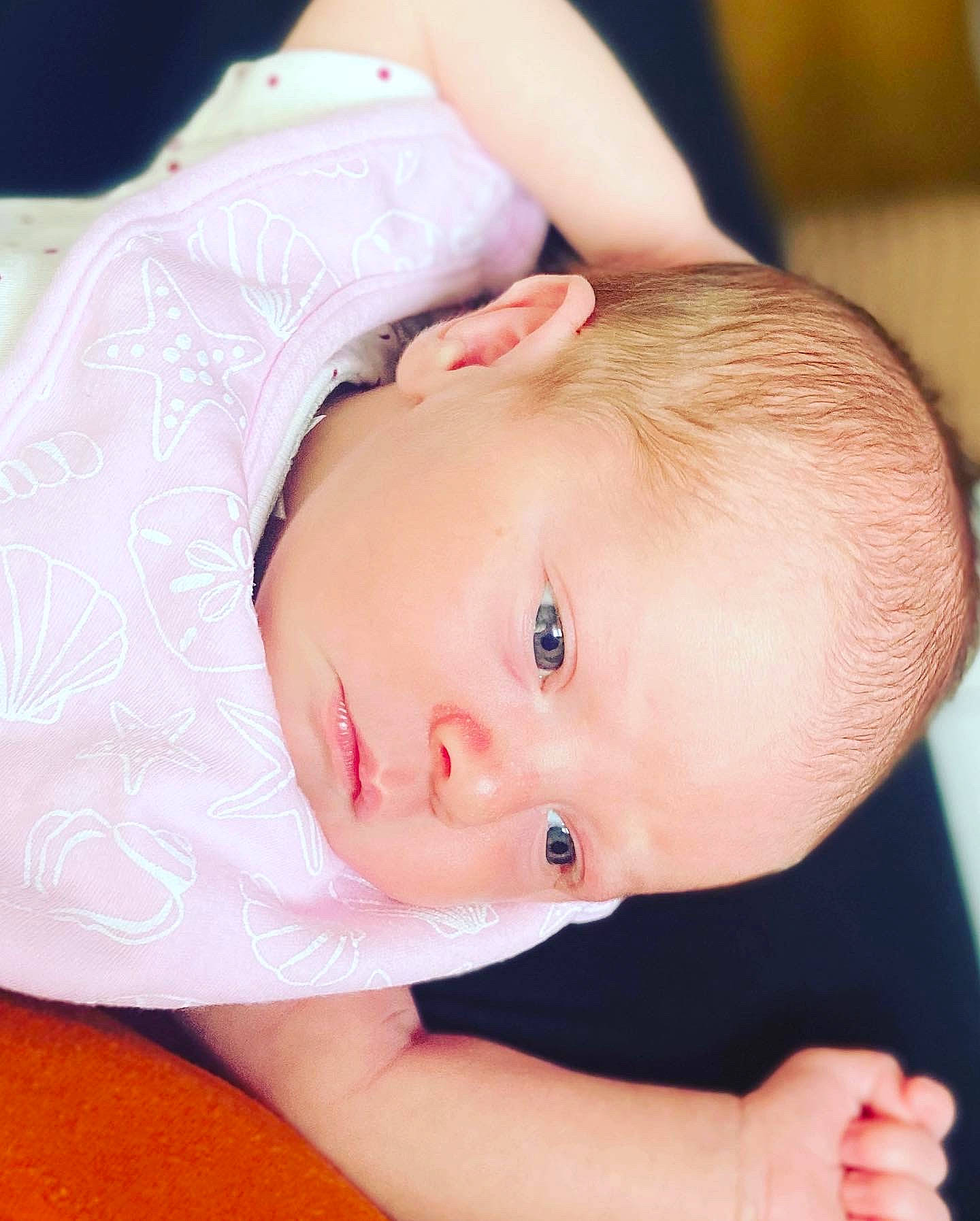 Ava is registered to the contest to win money with this photo: arm, baby, baby_toddler_clothing, cheek, chest, child, eye, eyelash, finger, hand, human_body, iris, lip, mouth, nose, person, pink, skin, sleeve, throat