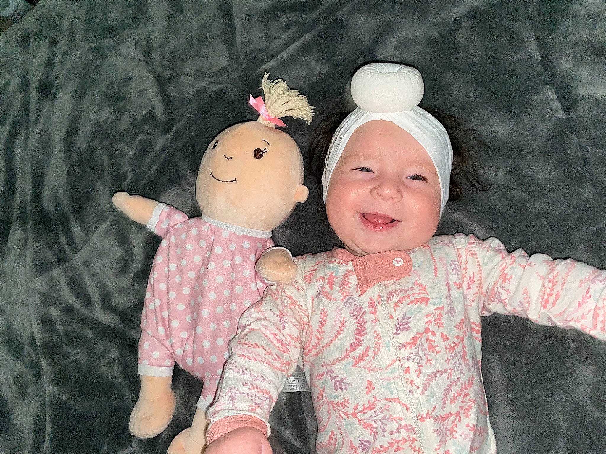 Austyn is registered to the contest to win money with this photo: baby_toddler_clothing, cheek, doll, event, eye, finger, fun, gesture, happy, head, headwear, human_body, joy, nose, pattern, person, pink, skin, sleeve, smile