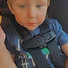 Hayse is registered to the contest to win money with this photo: child, toddler, baby, face, portrait, car, car_seat, seatbelt, buckled, indoors, vehicle, blue_shirt, blond_hair, blue_eyes, looking_at_camera, serious, digital_filter, glowing_horns, close_up, safe